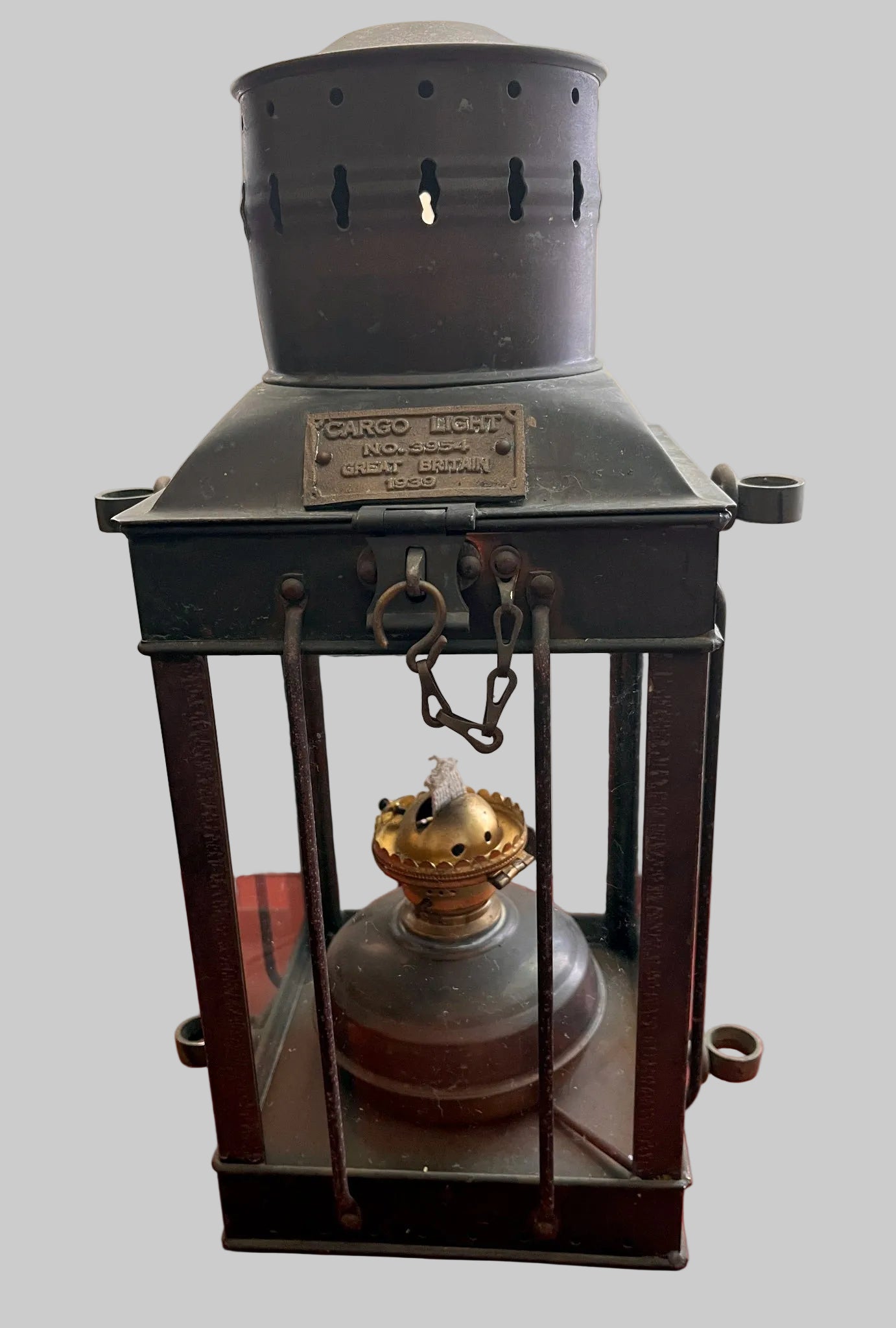 Vintage-style lantern with glass front on a red surface