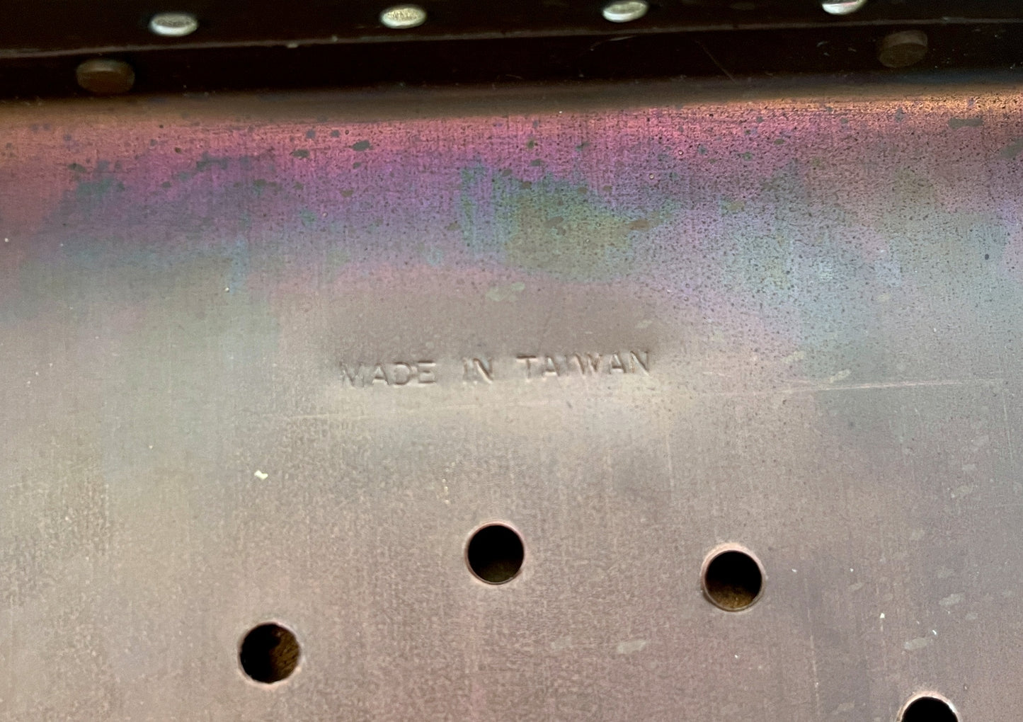 Metal surface with 'MADE IN TAIWAN' engraving and three holes.
