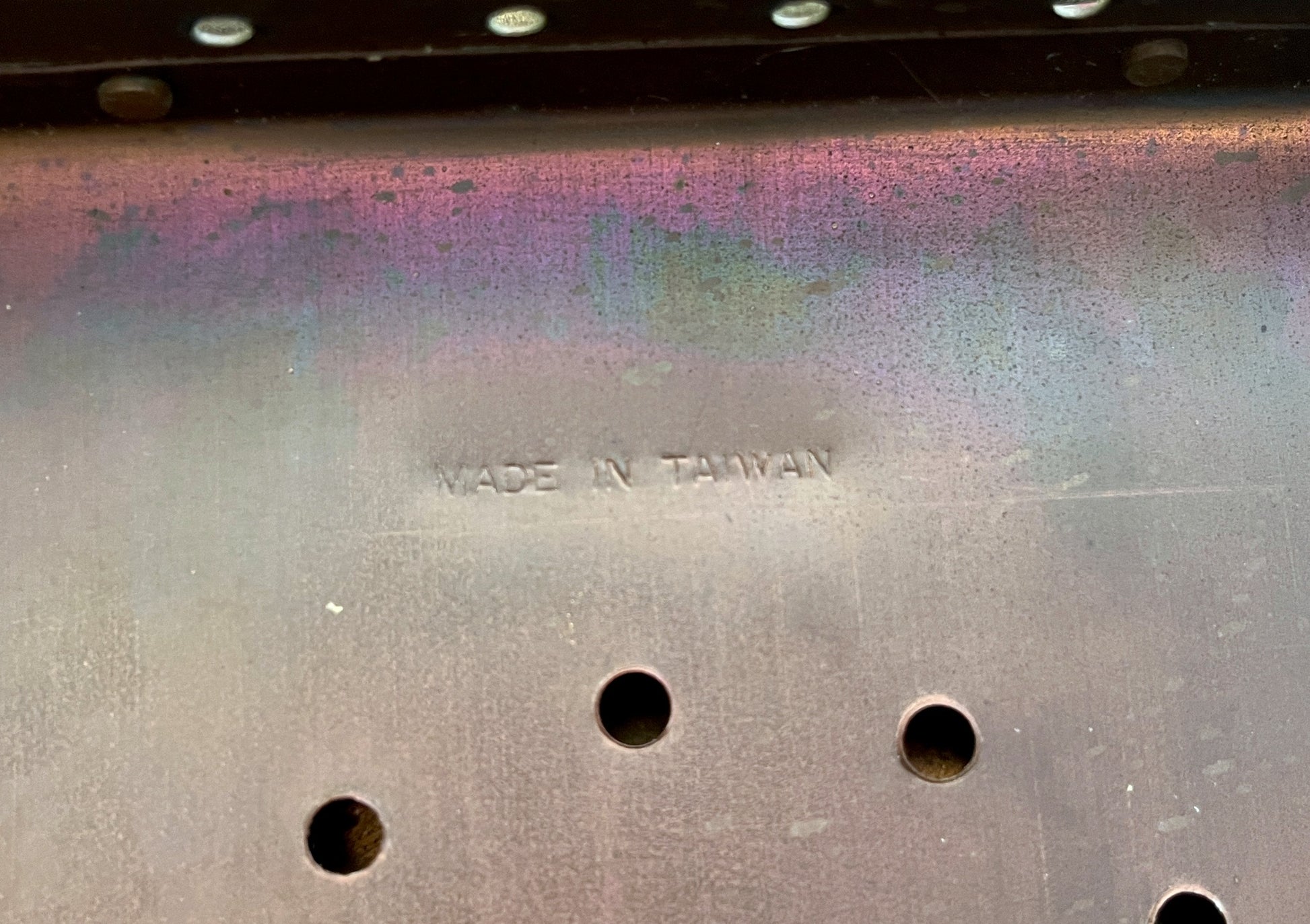 Metal surface with 'MADE IN TAIWAN' engraving and three holes.