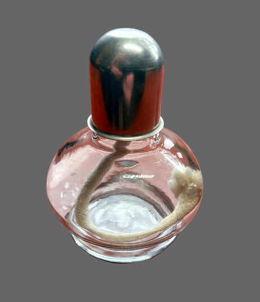 Clear glass bottle with a metal cap on a wooden surface