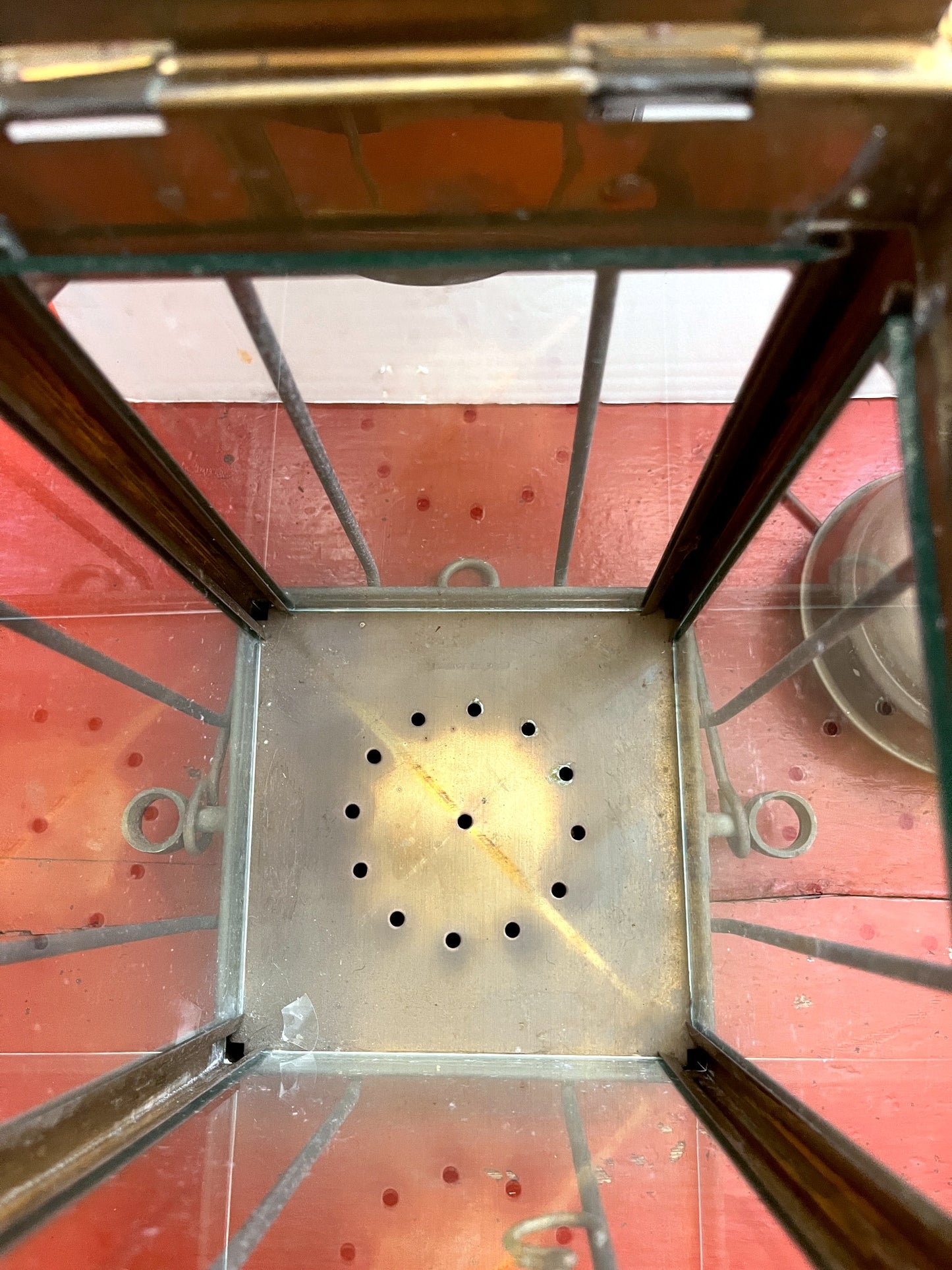 Metal stove top with perforated design on a red surface
