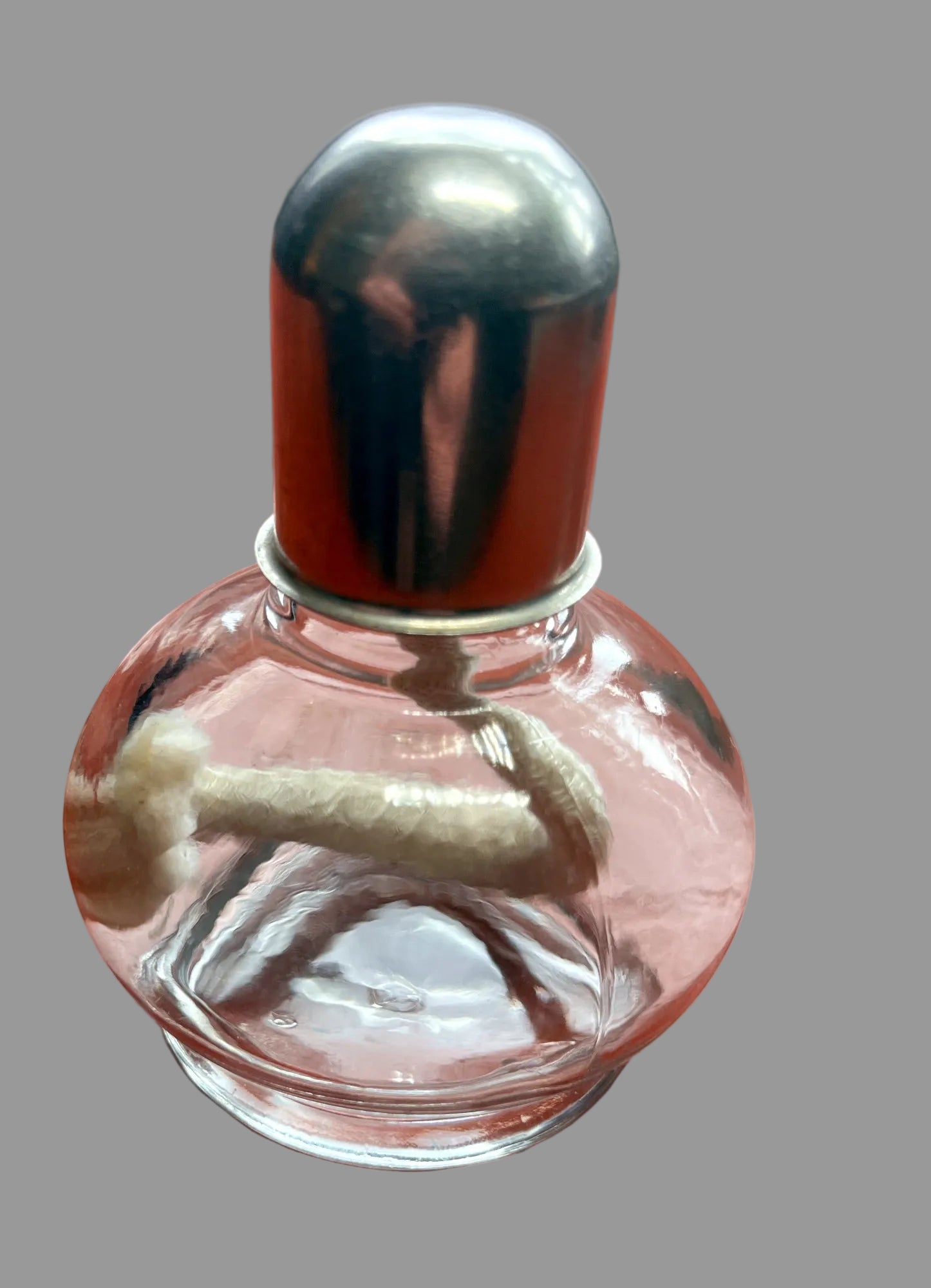 Small glass bottle with a metal cap on a wooden surface